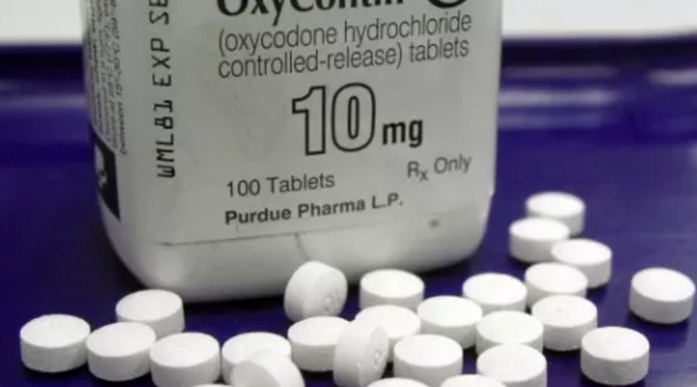 OxyConton pill bottle with round white pills surrounding it